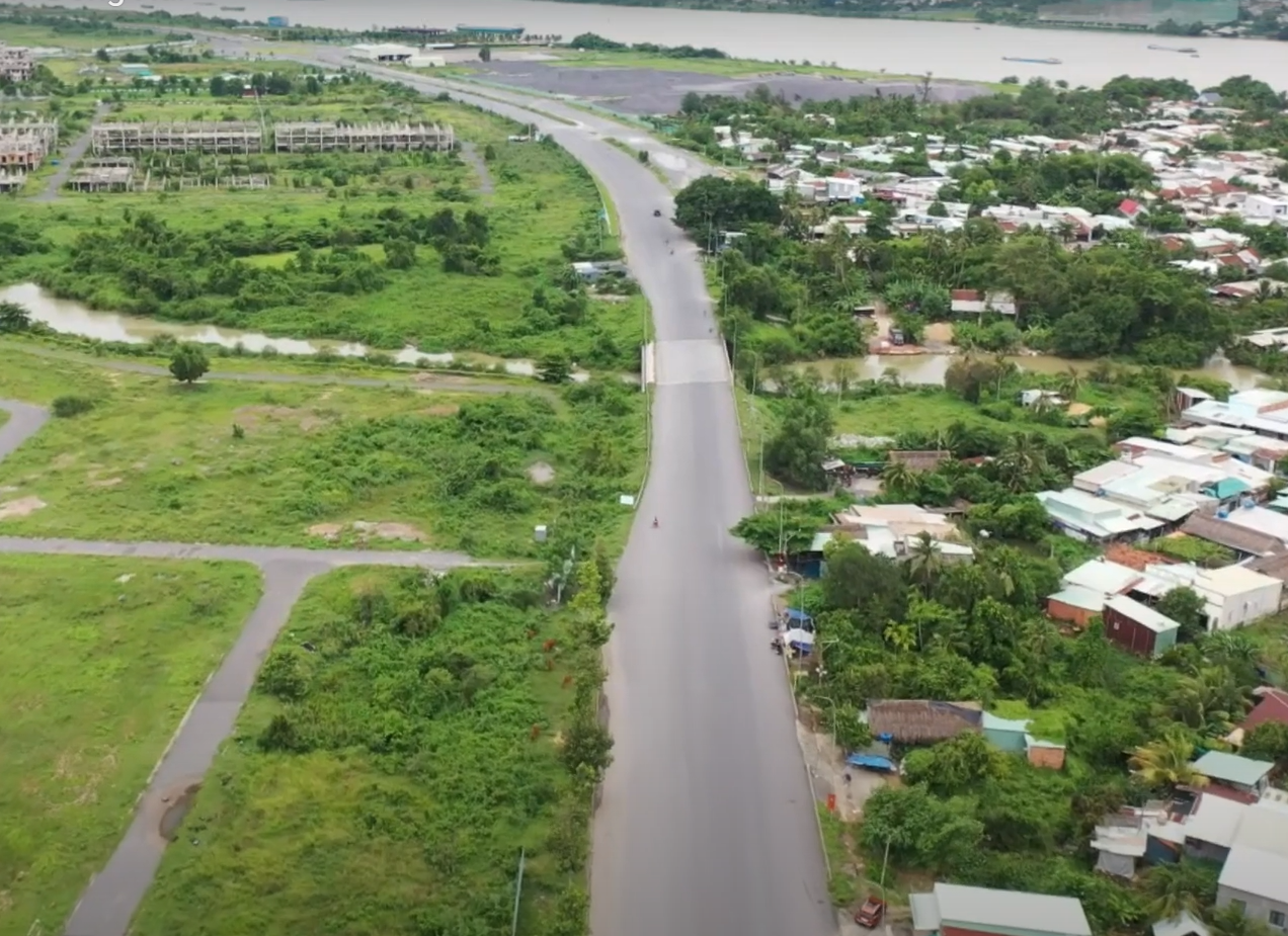 'A road between buildings and a body of water

AI-generated content may be incorrect.'